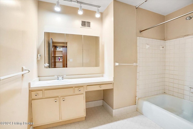 bathroom featuring vanity, tile patterned floors, and tiled shower / bath