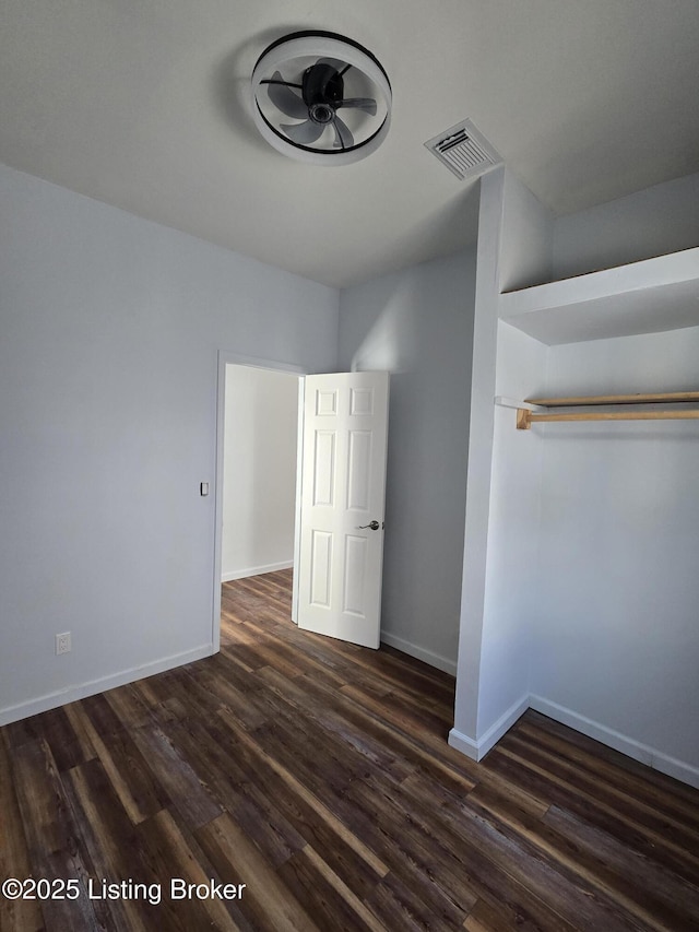 unfurnished bedroom with dark hardwood / wood-style flooring and a closet