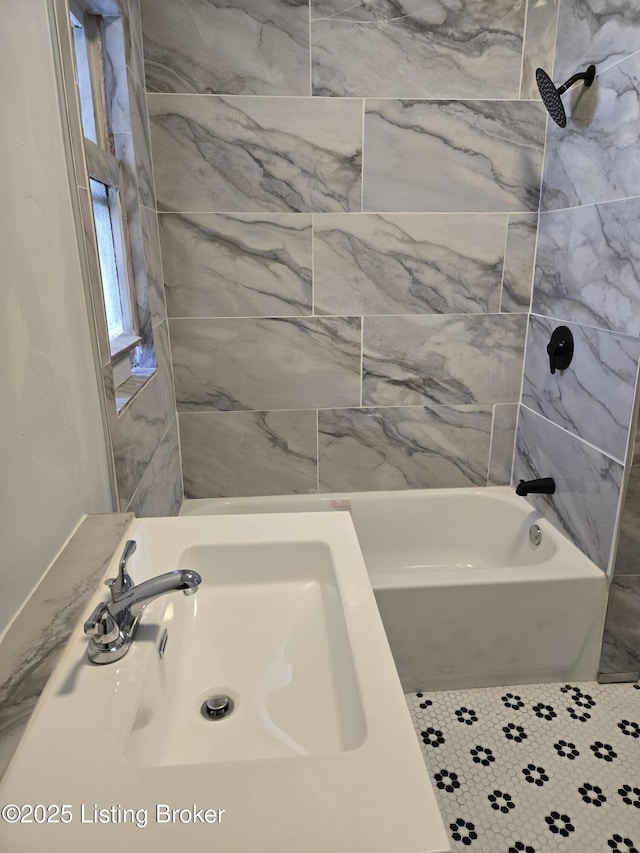 bathroom featuring tiled shower / bath and sink