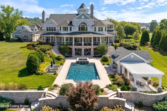 back of house with a swimming pool with hot tub, a patio area, a pergola, and a yard