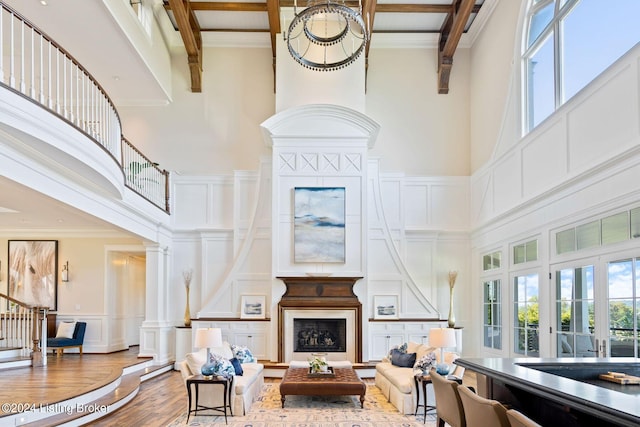 living room featuring french doors, a high ceiling, a healthy amount of sunlight, and beam ceiling