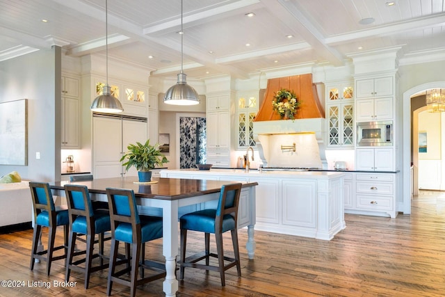 kitchen featuring pendant lighting, a large island, beam ceiling, and coffered ceiling