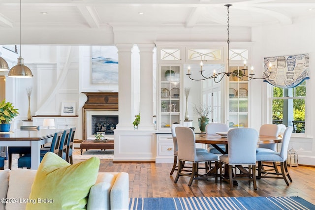 dining space with hardwood / wood-style flooring, beamed ceiling, ornamental molding, and an inviting chandelier