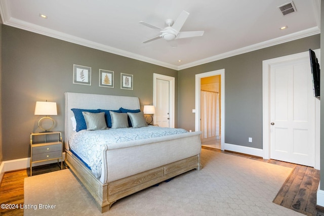 bedroom with hardwood / wood-style flooring, ceiling fan, and ornamental molding