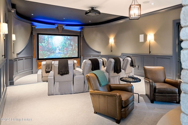 cinema room featuring crown molding, light carpet, and a tray ceiling