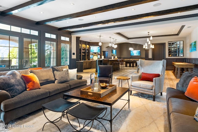 living room with light hardwood / wood-style flooring, beamed ceiling, and a notable chandelier