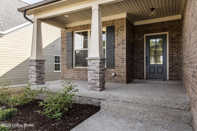 view of exterior entry featuring covered porch