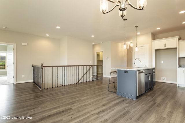 kitchen with dishwasher, a kitchen island with sink, white cabinets, sink, and hanging light fixtures