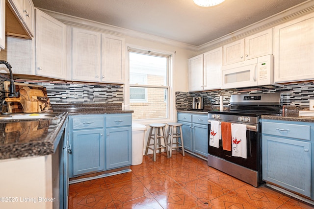 kitchen with white cabinets, stainless steel range with electric cooktop, sink, and blue cabinetry