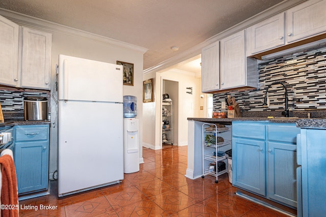 kitchen featuring white refrigerator, white cabinetry, ornamental molding, decorative backsplash, and blue cabinetry