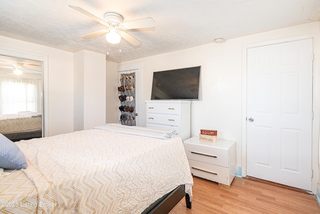 bedroom featuring a textured ceiling, ceiling fan, and light hardwood / wood-style flooring