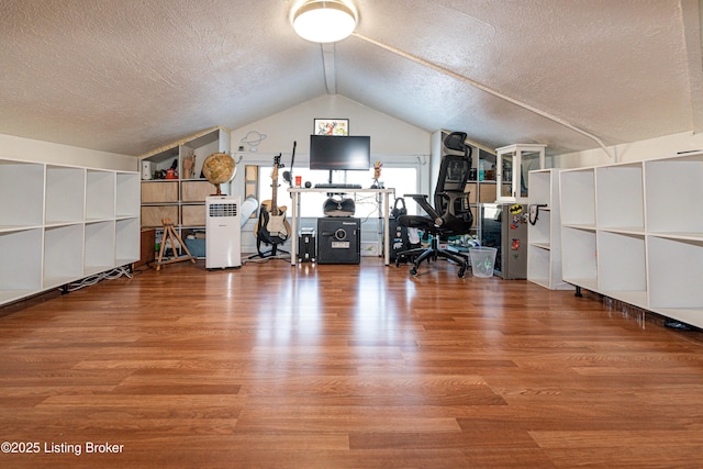 unfurnished office with lofted ceiling, a textured ceiling, and hardwood / wood-style floors