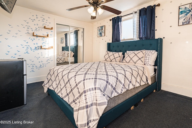 carpeted bedroom featuring stainless steel refrigerator, ceiling fan, and a closet