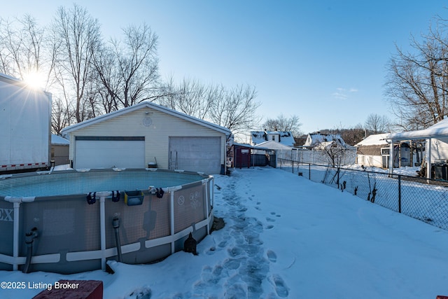 yard covered in snow featuring a garage and an outdoor structure