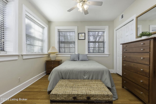 bedroom with ceiling fan, dark hardwood / wood-style flooring, and a closet