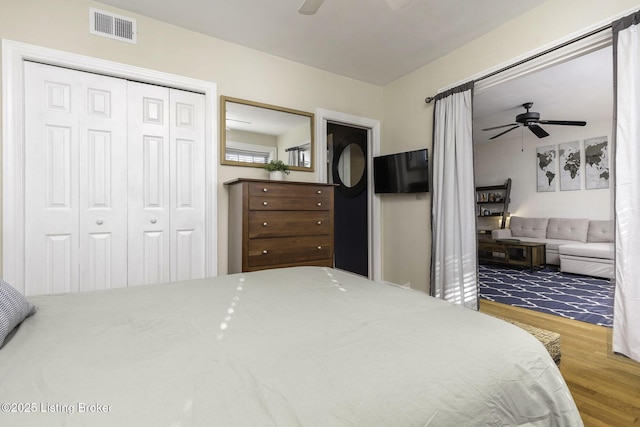 bedroom featuring hardwood / wood-style flooring, ceiling fan, and a closet