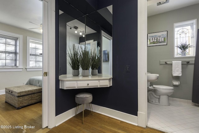 bathroom with ceiling fan, toilet, and wood-type flooring