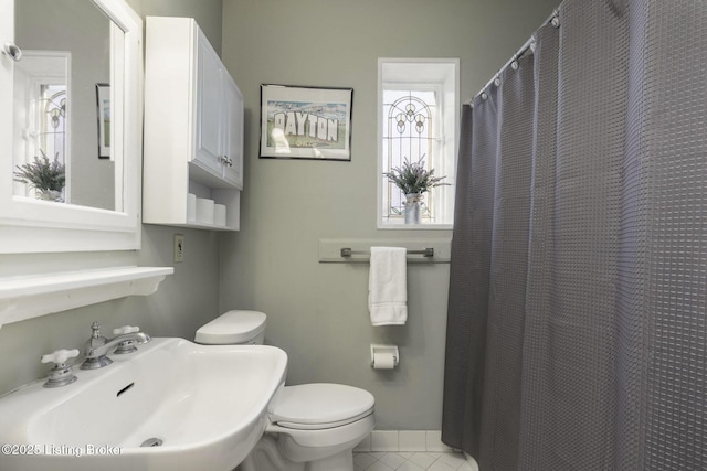 bathroom with sink, a shower with curtain, tile patterned floors, and toilet