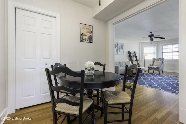 dining area with ceiling fan and wood-type flooring