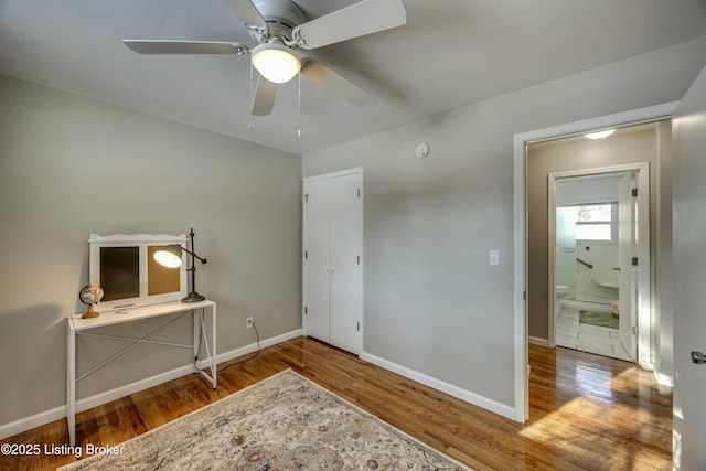 unfurnished bedroom with ceiling fan, baseboards, and wood finished floors