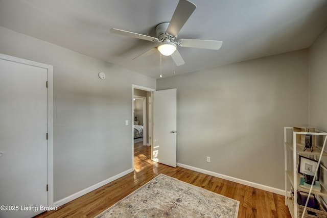 bedroom with ceiling fan, baseboards, and wood finished floors