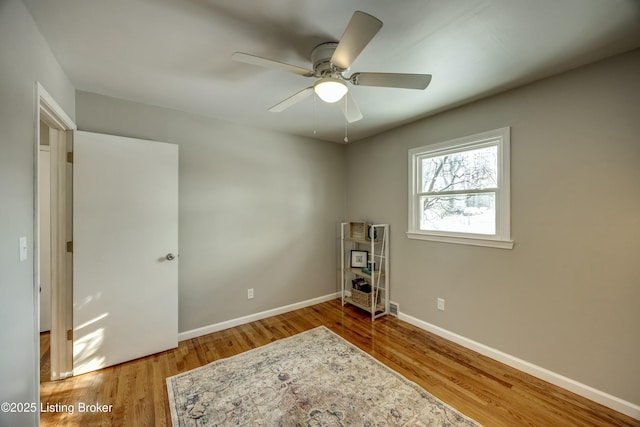 interior space featuring ceiling fan, baseboards, and wood finished floors