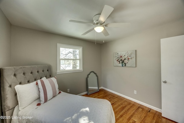 bedroom with a ceiling fan, baseboards, and wood finished floors