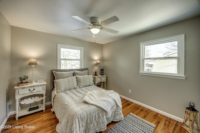 bedroom featuring a ceiling fan, baseboards, and wood finished floors