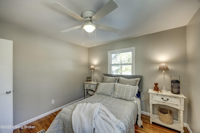 bedroom with ceiling fan, baseboards, and wood finished floors