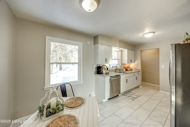 kitchen with visible vents, marble finish floor, stainless steel appliances, white cabinetry, and a sink