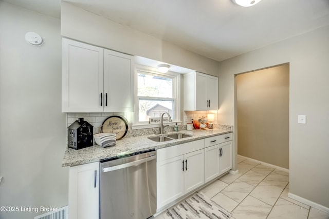 kitchen featuring decorative backsplash, dishwasher, marble finish floor, light stone countertops, and a sink