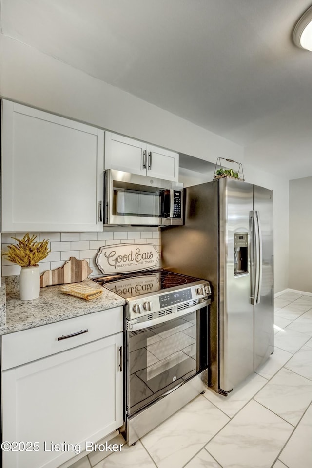 kitchen featuring white cabinets, marble finish floor, stainless steel appliances, and backsplash