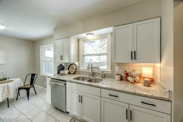 kitchen with a sink, white cabinetry, marble finish floor, stainless steel dishwasher, and backsplash