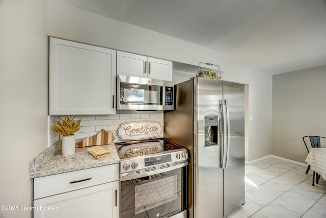 kitchen featuring light stone countertops, marble finish floor, stainless steel appliances, white cabinetry, and backsplash