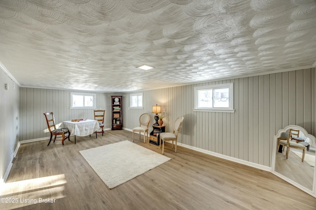 sitting room with a wealth of natural light, baseboards, and wood finished floors