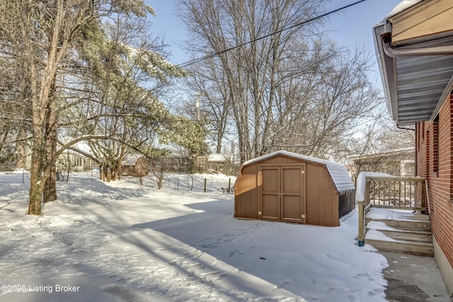 yard covered in snow featuring a shed