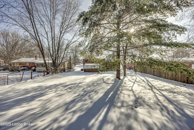 snowy yard with a jacuzzi and fence