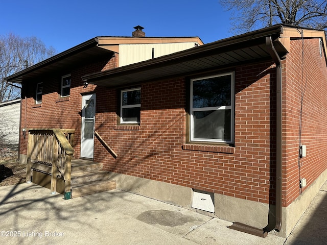 view of side of property with brick siding and crawl space