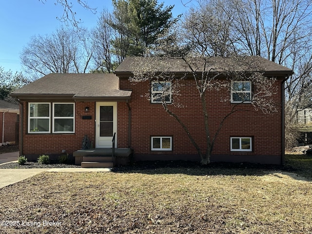 tri-level home featuring a front yard and brick siding