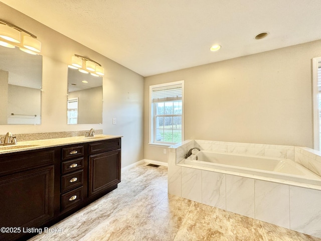 bathroom with a relaxing tiled tub and vanity