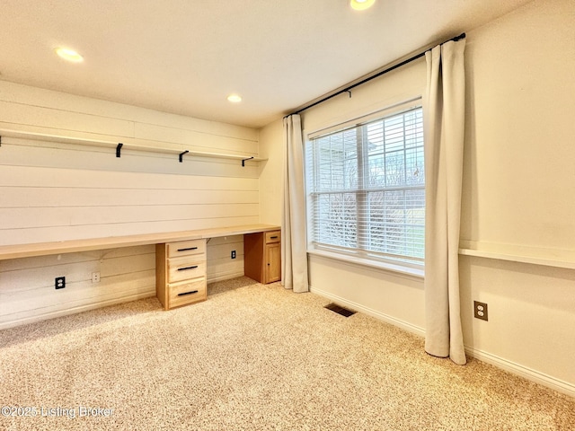 mudroom with light colored carpet and built in desk