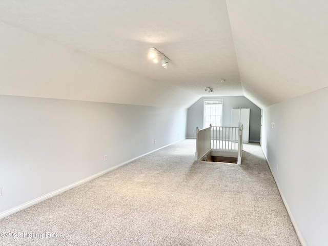 bonus room with light colored carpet and lofted ceiling