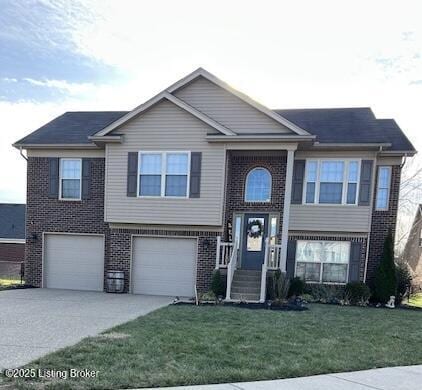 bi-level home with a garage and a front lawn