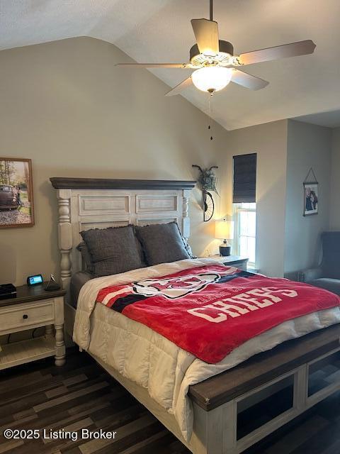 bedroom with dark hardwood / wood-style floors, vaulted ceiling, and ceiling fan