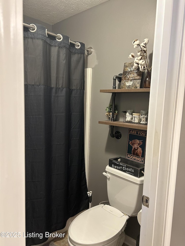 bathroom with a shower with curtain, a textured ceiling, and toilet