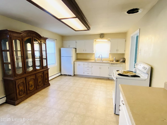 kitchen featuring a healthy amount of sunlight, sink, white appliances, and baseboard heating