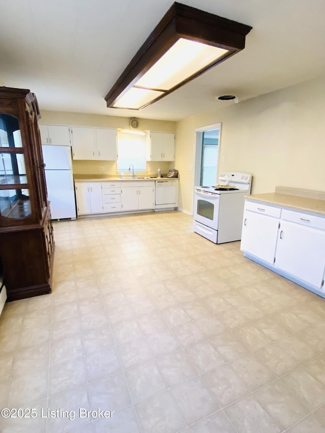 kitchen featuring white cabinetry, sink, and white appliances