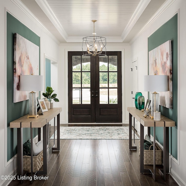 entryway with french doors, dark hardwood / wood-style flooring, crown molding, and a notable chandelier