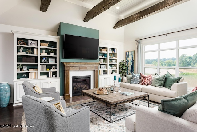 living room featuring a fireplace, beamed ceiling, wood-type flooring, and built in features