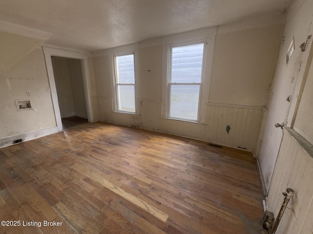 empty room featuring a textured ceiling and light hardwood / wood-style flooring